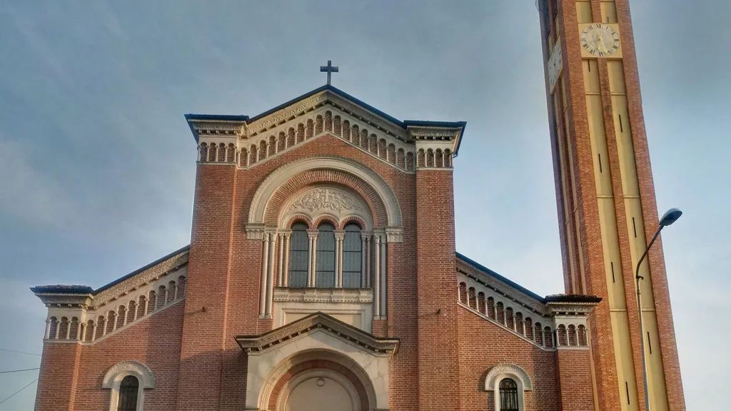 Facciata in mattoni della chiesa di Santa Maria Assunta a Sovizzo con campanile